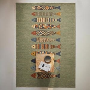 a vibrant rug with a unique fish design, including various colors and patterns, laid out on a wall.