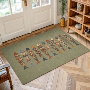 a rug with a unique fish design on it, placed on a wooden floor in a room with a door and a bookshelf.