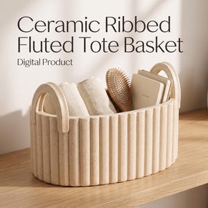 Pode incluir: Uma cesta de cerâmica bege com design canelado e duas alças integradas. A cesta contém tecidos enrolados de cor clara, uma escova de cabelo de madeira e pequenos cadernos. Texto: Ceramic Ribbed Fluted Tote Basket Digital Product.