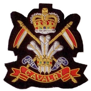 Puede incluir: Parche bordado con fondo negro, con una corona dorada, espadas cruzadas y una pancarta con la palabra "CAVALRY". El diseño incluye las frases "ICH" y "DIEN", con acentos rojos, blancos y azules.