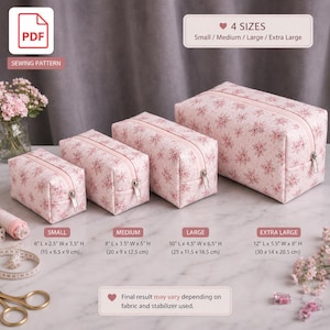 Könnte beinhalten: Vier Kosmetiktaschen mit Reißverschluss in verschiedenen Größen mit rosa Blumenmuster. Größen: Klein (15 x 6,5 x 9 cm), Mittel (20 x 9 x 12,5 cm), Groß (25 x 11,5 x 16,5 cm) und Extra Groß (30 x 14 x 20,5 cm).