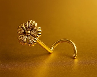 Könnte beinhalten: Ein goldfarbener Nasenring mit einem Blumenmuster. Die Blume hat detaillierte Blütenblätter und einen kleinen, runden Mittelpunkt. Der gebogene Stab ist für einfaches Einsetzen konzipiert. Der Schmuck ist vor einem goldenen Hintergrund platziert.