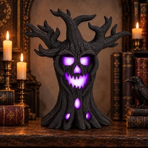May include: A black, textured tree-shaped sculpture with a gnarled, branch-like top and a hollowed-out face. The eyes, nose, and mouth openings emit a bright, glowing purple light, creating a spooky, illuminated effect on the dark surface.