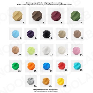 May include: A color chart displays 22 swatches of a spiral-shaped object in various colors, including beige, brown, burgundy, and green. The swatches are numbered and arranged in rows and columns. Text at the top states that colors may vary due to lighting.