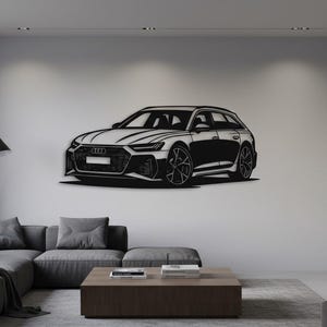 May include: A black and white metal wall art piece depicting a modern station wagon car. The car is mounted on a white wall in a living room setting. The car's design includes detailed wheels and a sleek body.