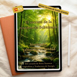 May include: A digital tablet displays a nature scene with text in Spanish: "El secreto de la resonancia Schumann." A stylus and a small orange notebook are next to the tablet. The tablet also has a Spanish flag icon.