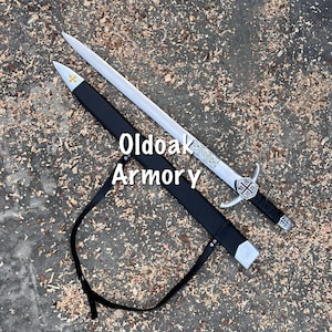 May include: A silver-toned metal sword with a black-wrapped handle and a cross-shaped emblem on the guard, accompanied by a black scabbard featuring a yellow cross detail and a black leather strap. The text Oldoak Armory is visible on the image.