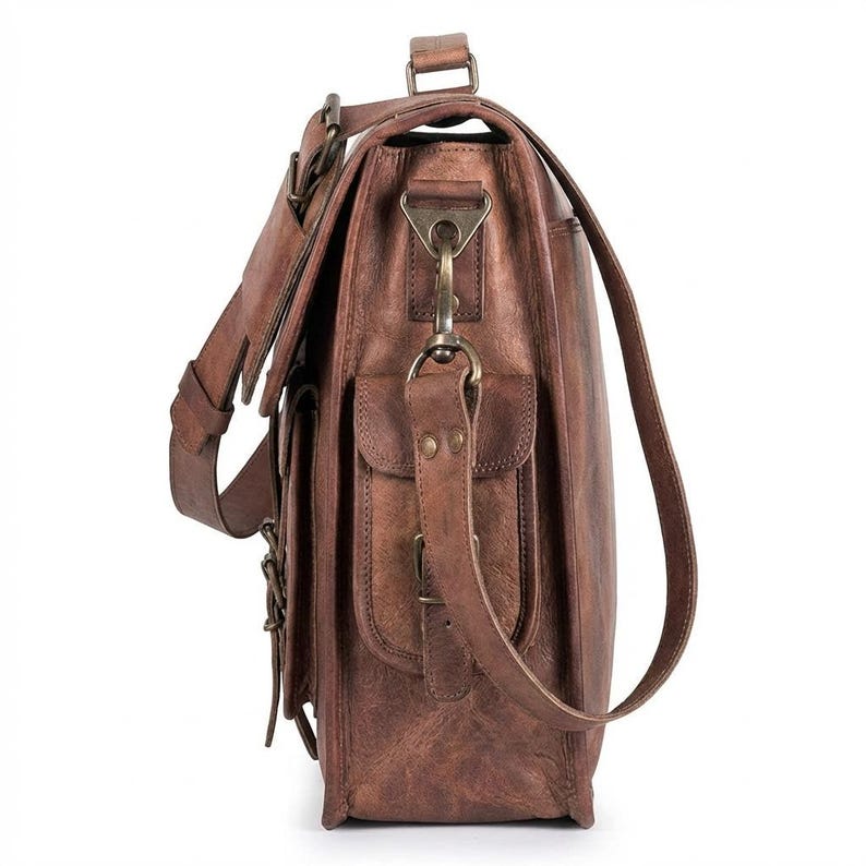 May include: A brown leather satchel with multiple pockets and a shoulder strap. The bag features metal hardware, including buckles and clasps. The leather has a distressed appearance, with variations in color and texture.