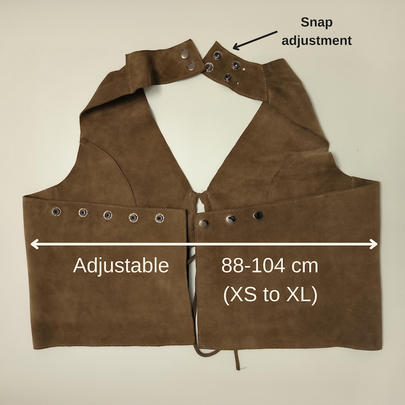 Może przedstawiać: Brązowa zamszowa kamizelka z regulacją na zatrzaski i oczkami. Kamizelka jest regulowana i mierzy 88-104 cm (XS do XL). Kamizelka ma dekolt w kształcie litery V i jest odpowiednia dla r&oacute;żnych typ&oacute;w sylwetki.