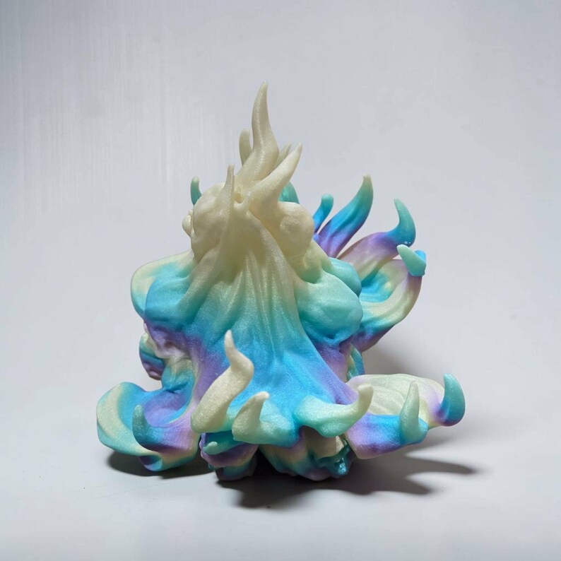 May include: A three-dimensional abstract sculpture featuring swirling, flame-like peaks and organic, flowing curves. The surface displays a gradient color palette of soft cream, vibrant sky blue, and muted purple, creating a blended, multi-colored effect.