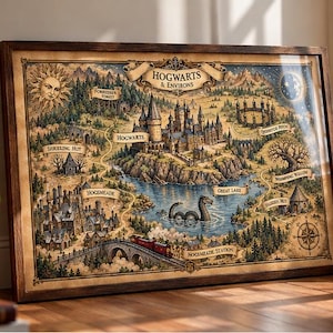 Może przedstawiać: Oprawiony wydruk mapy zatytułowany Hogwarts & Environs, przedstawiający szczegółową ilustrację zamku, Hogsmeade, Wielkiego Jeziora z wężem morskim oraz pociągu na torach, wszystko w odcieniach sepii i stonowanych barwach w ciemnej drewnianej ramie.