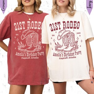 May include: Two t-shirts, one crimson and one ivory, each with a western-themed graphic. The design includes the text "21st Rodeo," a cowboy hat, boots, and the words "Amelia's Birthday Party, Flagstaff, Arizona."