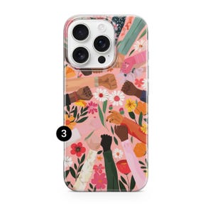 Puede incluir: Una funda para smartphone con fondo rosa y un patr&oacute;n de brazos de diversos tonos de piel levantados en solidaridad, intercalados con ilustraciones coloridas de varias flores y follaje. El n&uacute;mero 3 es visible en un c&iacute;rculo negro a la izquierda.