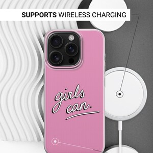 Puede incluir: Una funda de smartphone rosa con el texto negro "girls can." en letra cursiva. La funda tiene un recorte para una c&aacute;mara de tres lentes. El texto indica que es compatible con carga inal&aacute;mbrica y que los laterales no est&aacute;n impresos.