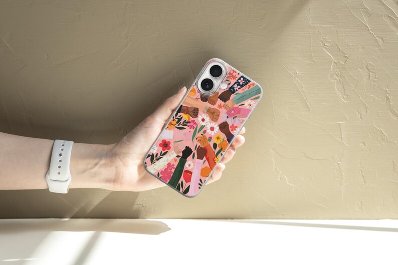 Puede incluir: Una funda de tel&eacute;fono transparente con una ilustraci&oacute;n colorida de diversas manos levantadas en solidaridad, intercaladas con patrones florales en tonos rosa, rojo, amarillo y blanco sobre un fondo transparente.