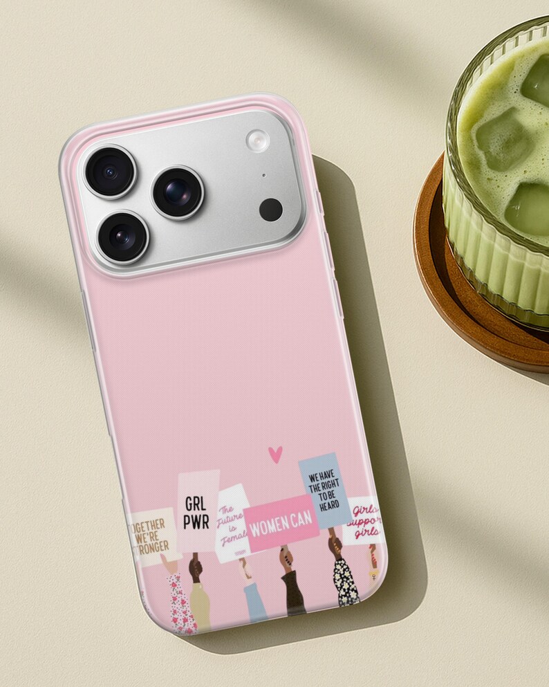 Puede incluir: Una funda de smartphone rosa claro con una ilustraci&oacute;n gr&aacute;fica de varias manos levantadas sosteniendo carteles de protesta. Los carteles muestran texto que incluye GRL PWR, WOMEN CAN y WE HAVE THE RIGHT TO BE HEARD, con un peque&ntilde;o coraz&oacute;n rosa.