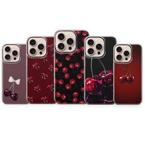 Puede incluir: Cinco fundas para teléfono con diseños de cerezas. Las fundas presentan varios patrones con temas de cerezas, incluyendo un lazo, cerezas dispersas e imágenes en primer plano de la fruta. Las fundas son en tonos de rojo, negro y morado.