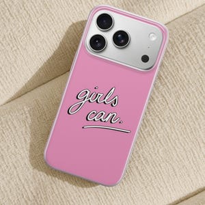 Puede incluir: Una funda de smartphone rosa con el texto "girls can." en una fuente cursiva blanca con borde negro. La funda tiene un borde transparente y est&aacute; dise&ntilde;ada para un tel&eacute;fono con un sistema de triple c&aacute;mara y flash visible en la parte posterior.