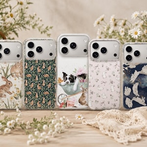 May include: Five clear smartphone cases featuring distinct designs: a rabbit and daisy pattern, a dark green rabbit print, a border collie in a wheelbarrow with a rabbit, a light pink rabbit and bow pattern, and a dark blue rabbit and star motif.