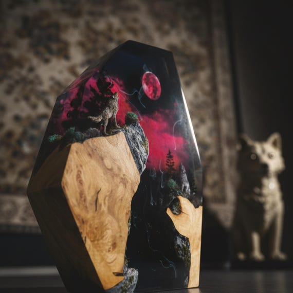 A blood-red moon rising over an epoxy-wood forest with a wolf silhouette — the live-edge wood integration lifts this above the standard resin-only lamp crowd.