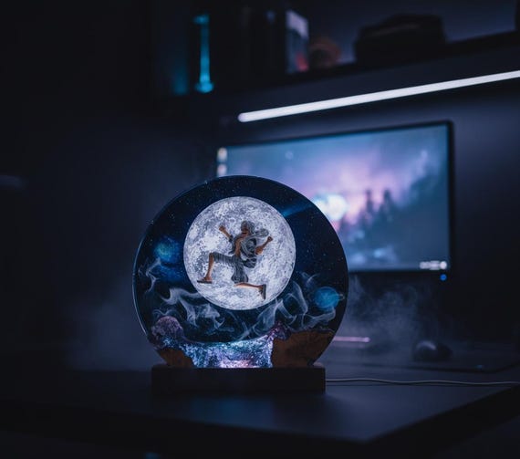 A handcrafted epoxy-resin moon lamp fused with a live-edge wood base and galaxy LED lighting inside — the kind of glowing desk sculpture that stops people mid-conversation.
