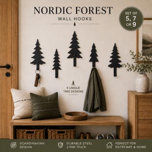 May include: A set of five black metal wall hooks shaped like pine trees, each 2 mm thick. The text NORDIC FOREST WALL HOOKS, SET OF 5, 7 OR 9, and 5 UNIQUE TREE DESIGNS is visible. The hooks are mounted on a wall above a wooden bench.