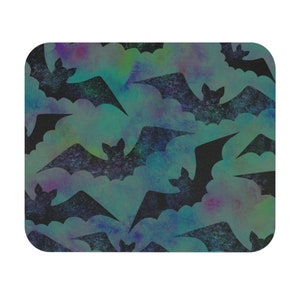 May include: A seamless pattern of black bats flying against a background of green, blue, and purple watercolor clouds.