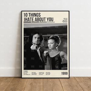 Könnte beinhalten: Ein gerahmtes Filmplakat für "10 Things I Hate About You" mit zwei Schauspielern. Das Poster hat einen schwarzen Rahmen und einen cremefarbenen Hintergrund mit dem Filmtitel oben. Das Jahr 1999 ist unten abgebildet.