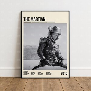 May include: Black and white movie poster for "The Martian" featuring a man in a spacesuit. The poster includes the movie title, the year 2015, and the names of the actors. The background is a desert landscape.