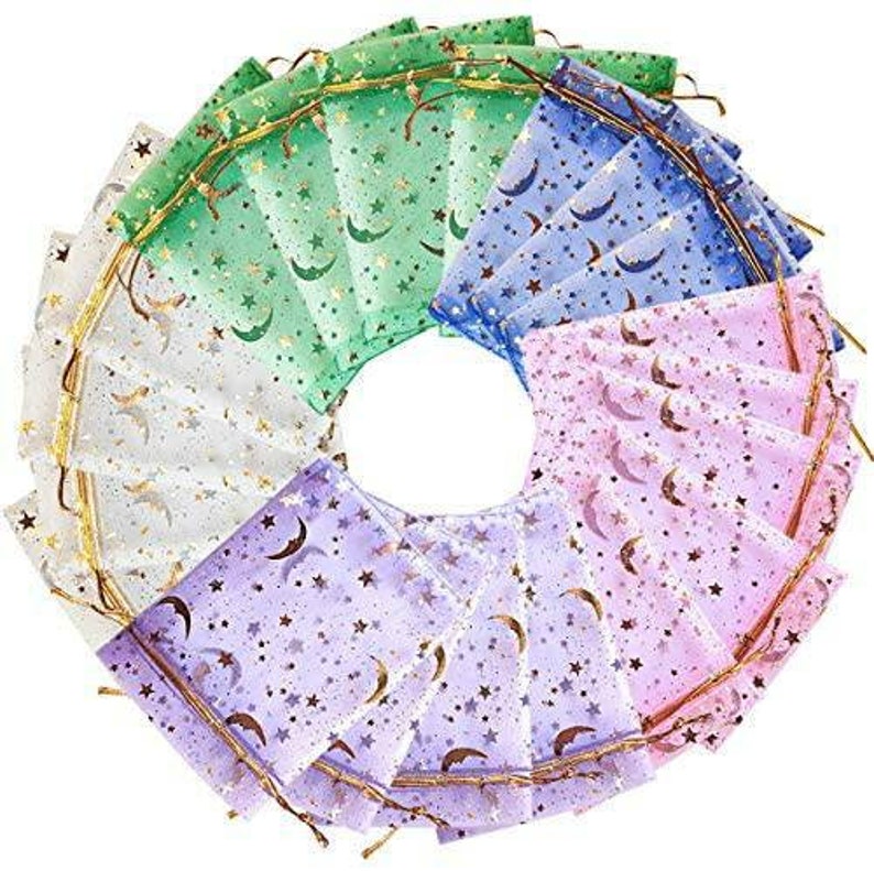 May include: A set of 15 sheer organza gift bags with a gold glitter moon and star pattern. The bags are in four colors: white, light purple, light pink, and green.