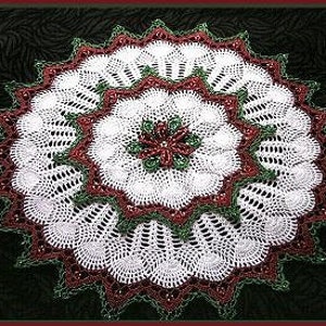 May include: White crochet doily with a red and green beaded center. The doily has a scalloped edge and is made with a delicate lace pattern.