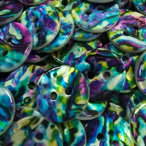 May include: A collection of round, two-hole buttons featuring a swirling, iridescent pattern of vibrant purple, bright teal, lime green, and white colors. Each button has a smooth, glossy finish with a marbled appearance throughout the surface.
