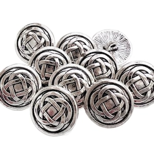 May include: A collection of silver-colored buttons with a Celtic knot design. The buttons are round with a textured finish and a shank on the back. The buttons are suitable for sewing projects.