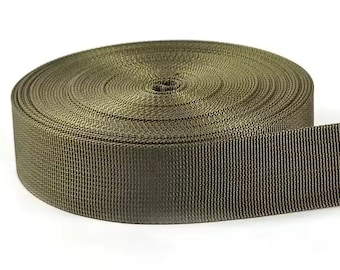 May include: A roll of olive drab nylon webbing. The webbing is tightly woven and appears durable. The roll is circular, with the end of the webbing extending outward. The background is white.