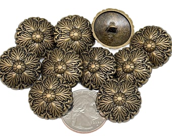 May include: A collection of antique brass-colored buttons with a floral design. The buttons are arranged on a white surface, with a U.S. quarter for size comparison. The buttons have a detailed, embossed pattern.