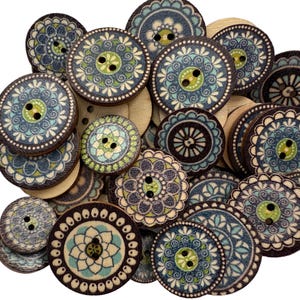 May include: A collection of wooden buttons with a floral design in shades of blue, green, and cream. The buttons are round with two or four holes for sewing. The buttons vary in size and pattern, creating a visually appealing assortment.