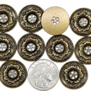 May include: A collection of antique brass-colored buttons with a floral design. Each button features a raised flower with a central cluster of small holes. A U.S. quarter is included for size comparison. The buttons have an aged, vintage appearance.