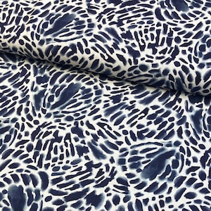 May include: White fabric with a blue abstract pattern of swirling shapes and dots. The fabric has a soft, flowing texture.