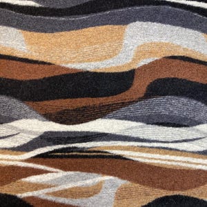 May include: Abstract pattern fabric with wavy lines in shades of brown, black, grey, and white.