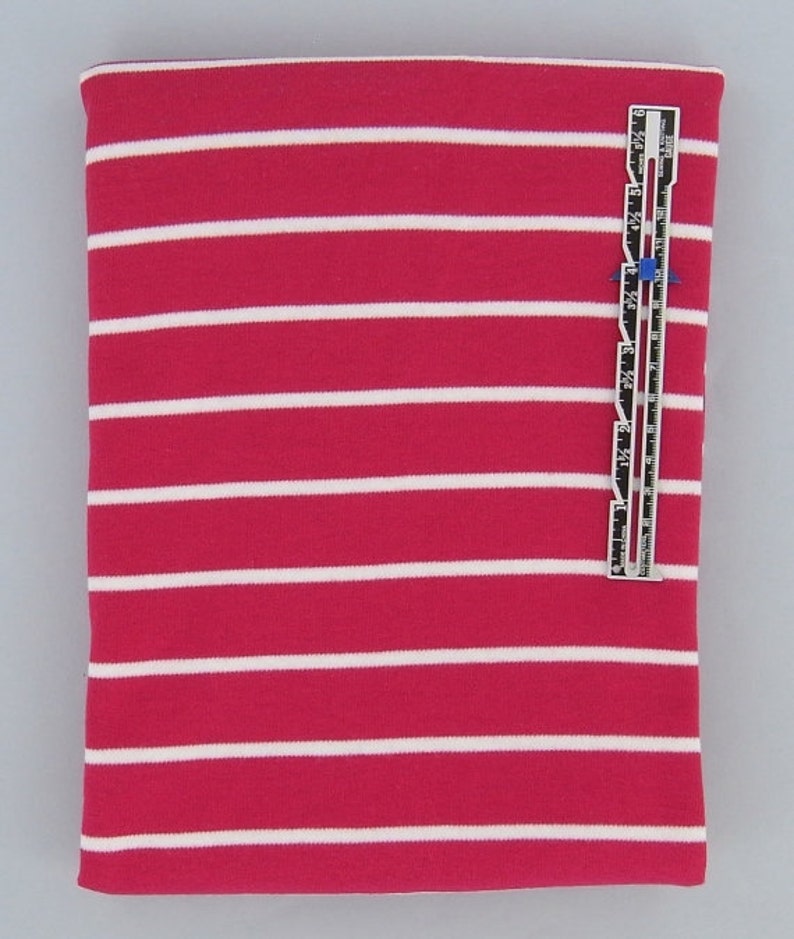 May include: A close-up of a pink and white striped fabric. The fabric is a knit and has a soft, stretchy feel. The stripes are about 1 inch wide.