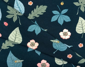 May include: Dark navy fabric with a repeating pattern of leaves, flowers, and insects. The leaves are in shades of green and blue, with pink and yellow flowers and small insects scattered throughout the design. A nature-themed textile.