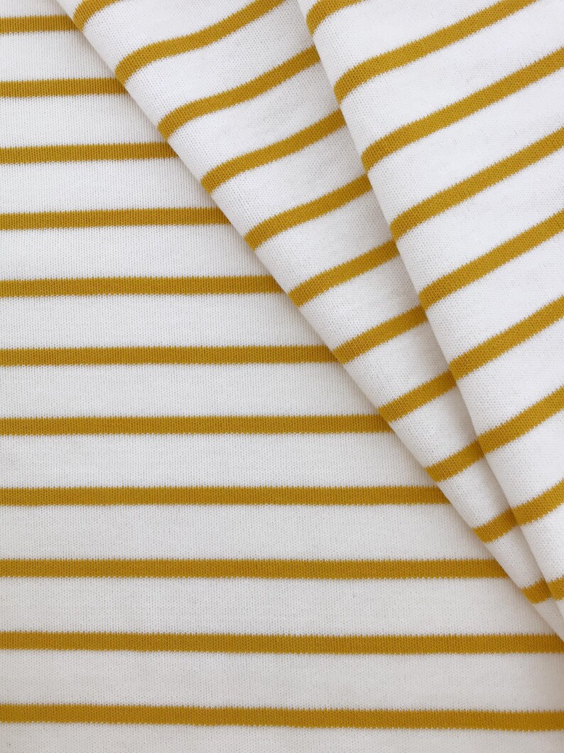 May include: White fabric with horizontal yellow stripes. The fabric is folded in half, showing the stripes on both sides.