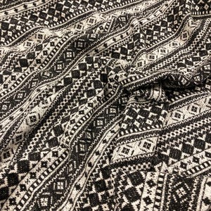 May include: Black and white patterned fabric with a geometric design. The fabric is woven and has a textured surface.