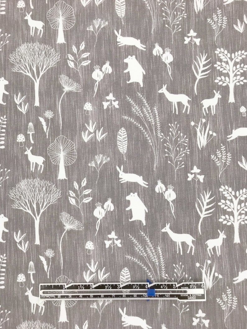 May include: A gray fabric with a white repeating pattern of woodland animals, trees, and plants. The pattern includes deer, bears, rabbits, mushrooms, and various types of foliage.