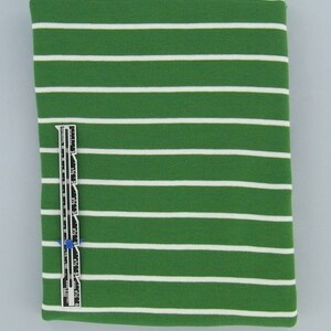 May include: Green and white striped fabric with a white measuring tape.