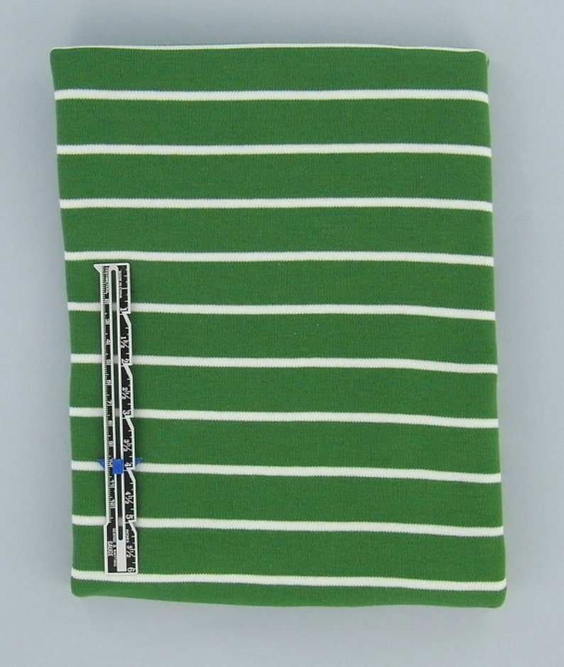 May include: Green and white striped fabric with a white measuring tape.