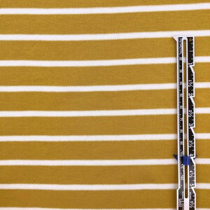 May include: Mustard yellow and white striped fabric with a ruler measuring 6 inches.