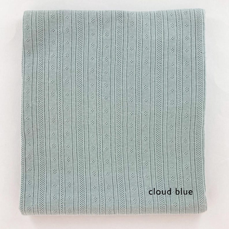 Peut inclure: Un tissu tricot&eacute; bleu clair avec un motif textur&eacute;. Le tissu a un l&eacute;ger brillant et une sensation douce et fluide. Le texte "cloud blue" est imprim&eacute; sur le tissu.
