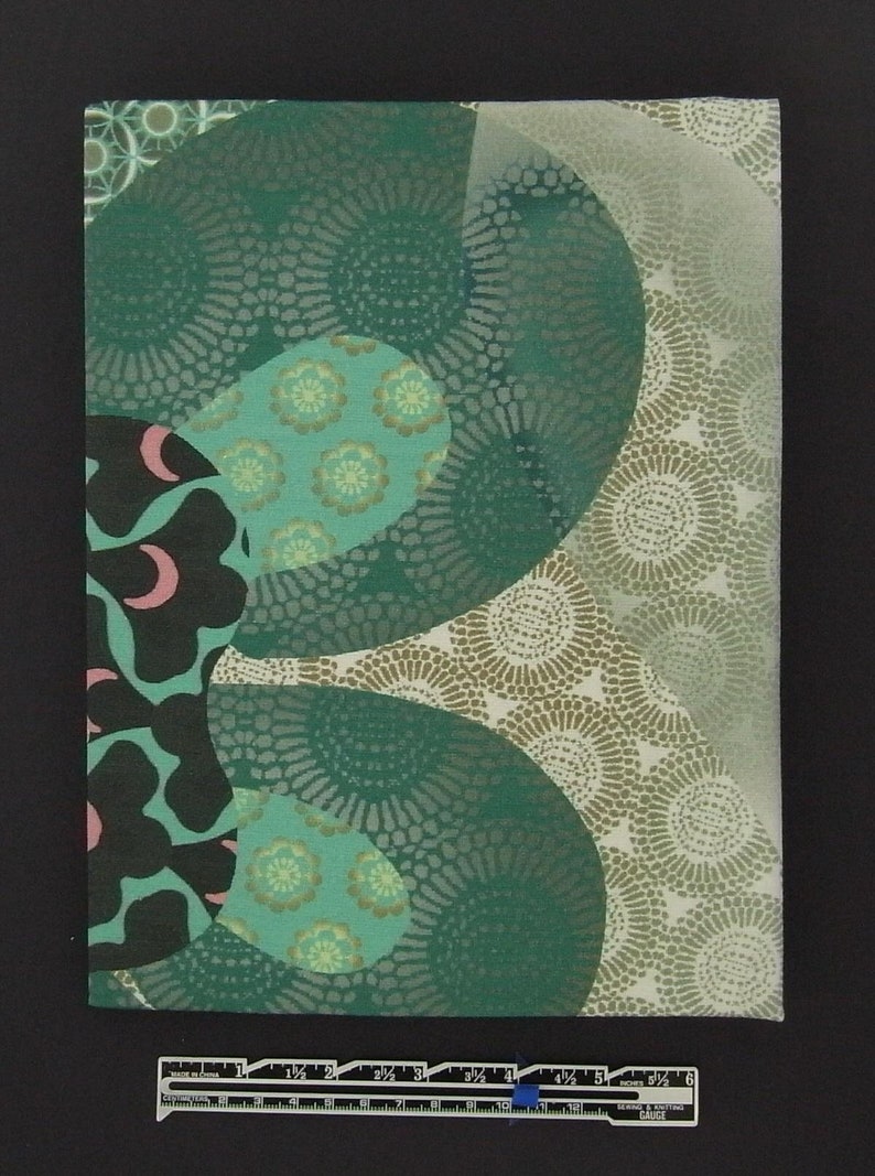 May include: A green and brown fabric with a repeating pattern of circles and flowers. The fabric has a textured surface and a subtle sheen.