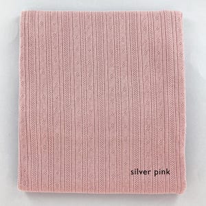 Peut inclure: Un tissu tricot&eacute; rose argent&eacute; avec un motif textur&eacute;. Le tissu est doux et a un l&eacute;ger &eacute;clat.